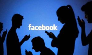People are silhouetted as they pose with laptops in front of a screen projected with a Facebook logo, in this picture illustration taken in Zenica October 29, 2014. Facebook Inc warned on Tuesday of a dramatic increase in spending in 2015 and projected a slowdown in revenue growth this quarter, slicing a tenth off its market value. Facebook shares fell 7.7 percent in premarket trading the day after the social network announced an increase in spending in 2015 and projected a slowdown in revenue growth this quarter. REUTERS/Dado Ruvic (BOSNIA AND HERZEGOVINABUSINESS LOGO - Tags: BUSINESS SCIENCE TECHNOLOGY LOGO TPX IMAGES OF THE DAY)